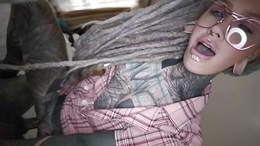 Татуированная девка в очках берет в рот большущий хуй и сношается в задницу